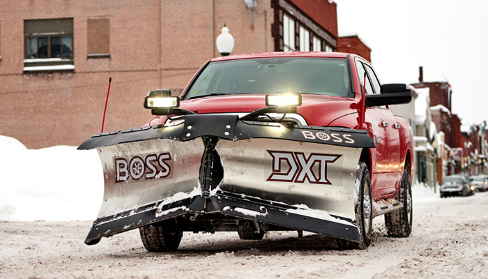 red maple leaf lawn maintenance truck with snow plow slider backed into residential driveway